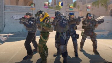 Cinco personagens antiterroristas de Counter-Strike 2 estão lado a lado em um pátio de pedra, apontando rifles e pistolas. Cada jogador tem uma etiqueta colorida acima de sua cabeça (laranja, roxo, CS2, verde, azul) e usa diferentes uniformes táticos, capacetes e equipamentos