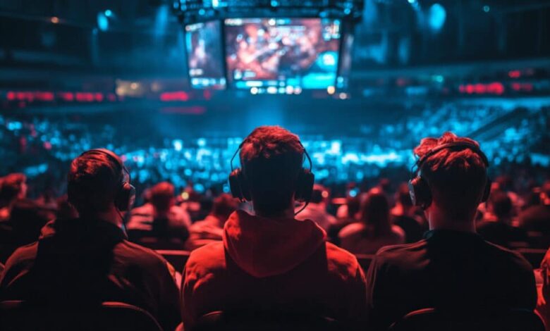 Os espectadores assistem a uma partida de esportes eletrônicos ao vivo em telas gigantes durante um torneio lotado