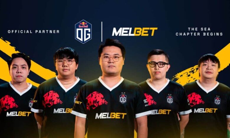 Imagem da escalação do OG Esports Dota 2 vestindo camisetas OG Esports em um fundo azul e amarelo. Os logotipos OG Esports e Melbet estão acima dos jogadores