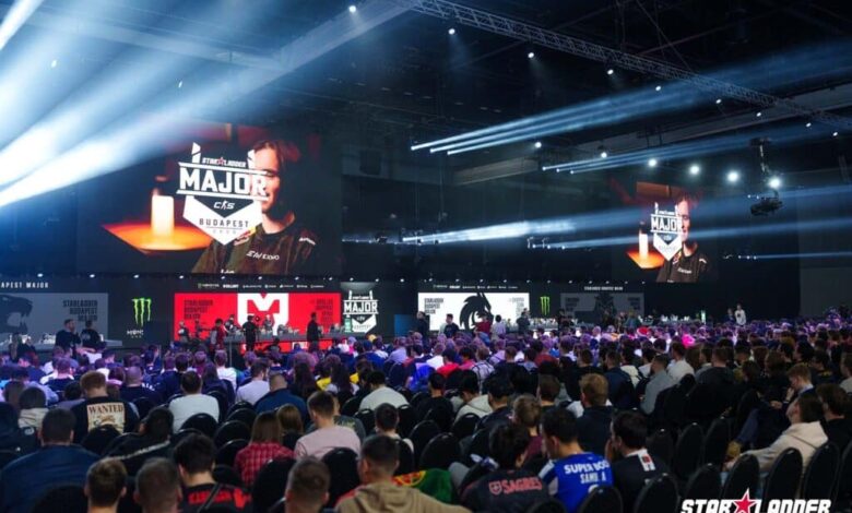 Imagem do palco StarLadder Budapest Major 2025 com logotipos de equipes projetados em telas