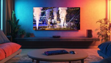 A imagem mostra uma sala de estar com uma TV transmitindo um evento de e-sports. A tela mostra jogadores da equipe de esportes eletrônicos Team Falcons comemorando sua vitória