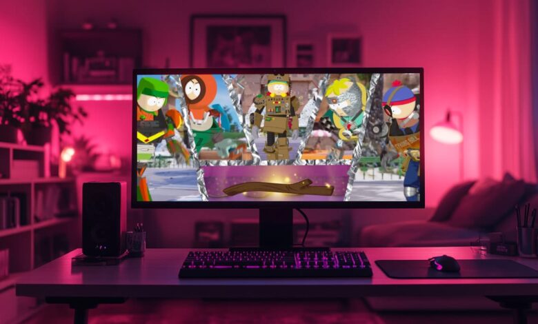 Um monitor de computador em uma mesa exibe o jogo Fortnite com personagens de South Park, incluindo Stan, Kenny, Butters, Kyle e Cartman